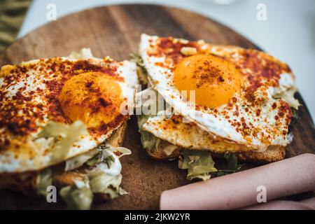Eine Nahaufnahme einer gerösteten Brotscheibe mit Salat und Spiegeleiern mit Paprika darauf Stockfoto