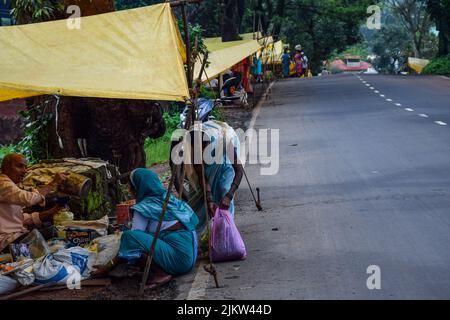 Kolhapur, Indien, 15. 2019. September; Stockfoto der 50- bis 60-jährigen indischen Frauen, die Saree tragen und in der Dorfwoche Lebensmittel beim Straßenhändler kaufen Stockfoto