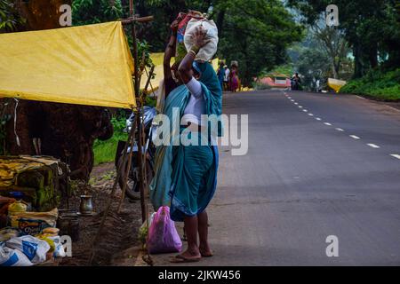 Kolhapur, Indien, 15. 2019. September; Stockfoto der 50- bis 60-jährigen indischen Frauen, die Saree tragen und in der Dorfwoche Lebensmittel beim Straßenhändler kaufen Stockfoto