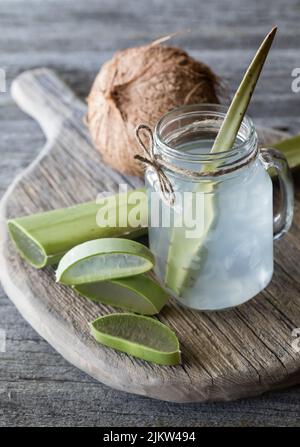 Kokoswasser mit Aloe Vera gemischt, umgeben von Stücken von Aloe. Stockfoto