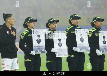 Polizeibeamte halten das Foto eines Polizeikollegen, der im Clan del Golfo-Waffenplan getötet wurde, und in der Mitte befinden sich die Independiente Santa Fe-Spieler L Stockfoto