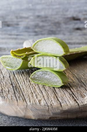 Stücke von Aloe Vera in einem Haufen auf einem rustikalen Holzbrett. Stockfoto