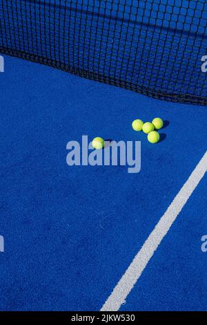 Paddeln Sie Tennisbälle am Netz auf einem blauen Paddle-Tennisplatz Stockfoto