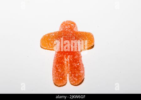 Eine Nahaufnahme einer orangefarbenen Marmeladenfigur, isoliert auf weißem Hintergrund. Stockfoto