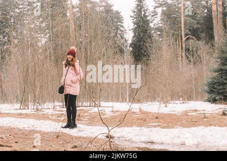 Schöne Frau in einem Wald an einem Frühlingsnachmittag, noch ziemlich kalt, Bilder mit Amplitude, mit Weitwinkel gemacht Stockfoto