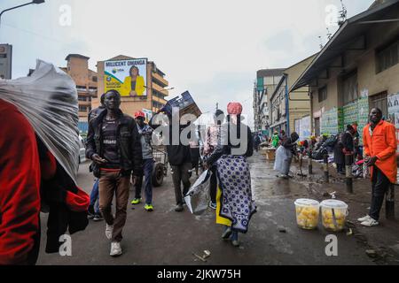 Fußgänger kommen an Straßenhändlern vorbei, die ihre Produkte auf den Straßen des zentralen Geschäftsviertels von Nairobi in Kenia verkaufen. Die meisten kenianischen Schulen waren auf Augus Stockfoto