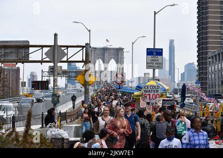 Touristen kommen wieder nach New York City. Am 13. April 2022 läuft eine große Menschenmenge über die Brooklyn Bridge in New York City. Stockfoto