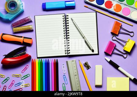 Ein Draufsicht auf fliederartigen Hintergrund, verschiedene Schulmaterialien, das Konzept von Bildung und Ausbildung. Stockfoto