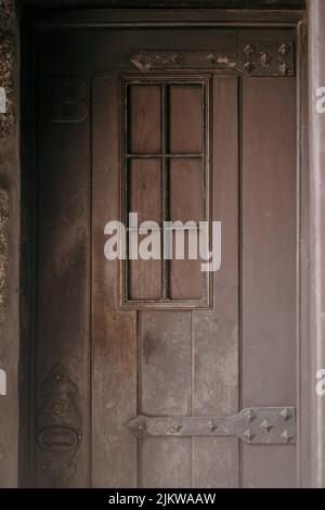 Eine vertikale Aufnahme einer alten, hölzernen Tür eines Hauses Stockfoto