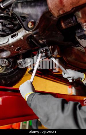 Kfz-Mechaniker, der Radausrichtungssensoren installiert und die Autoaufhängung eingestellt hat. Automechaniker bei der Arbeit Stockfoto
