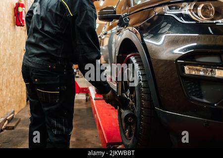 Ein Automechaniker, der Sensoren für die Spureinstellung installiert Stockfoto