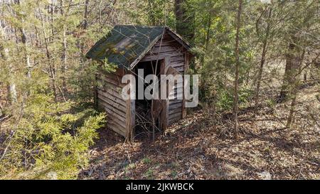 Altes verlassene Nebengebäude in der Nähe des alten Hauses tief in Wäldern Stockfoto