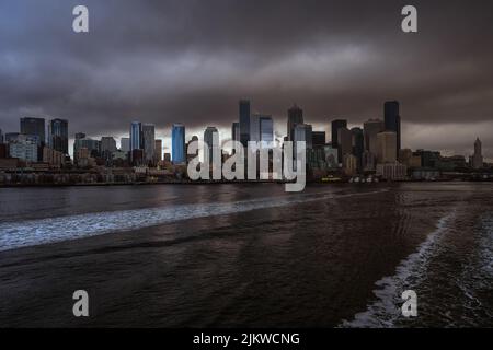 SKYLINE VON SEATTLE VON DER ELLIOTT BAY AUS MIT EINER BANK VON STURMWOLKEN UND EINER NACHBILDUNG IM WASSER Stockfoto