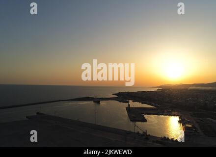 Ein atemberaubender Blick auf den Sonnenuntergang über dem Meer am Hafen Stockfoto