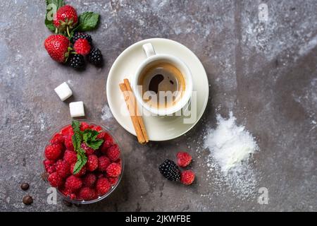 Panakota Dessert mit frischen Himbeeren und einer Tasse Kaffee auf einem betonierten Hintergrund Draufsicht. Stockfoto