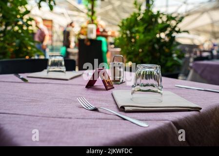 Tisch mit Geschirr im modernen Restaurant im Sommer. Stockfoto