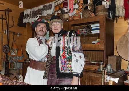 Mann und Frau in ukrainischen Hutsul-Kostümen zeigen die alte traditionelle Hutsul-Lebensart in Yaremche Ukraine. Stockfoto