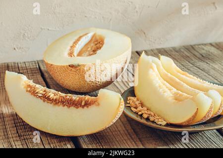 Melone in Scheiben auf Holztisch Stockfoto