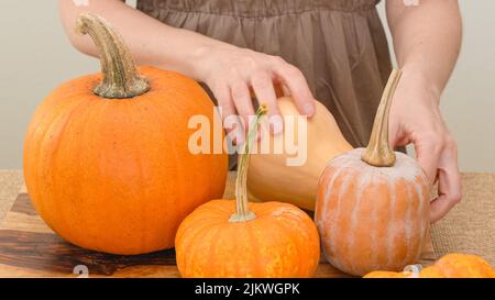 Kürbis, Butternut, Squash Nahaufnahme auf Holz Schneidebrett. Lifestyle, Frau Hände Stockfoto