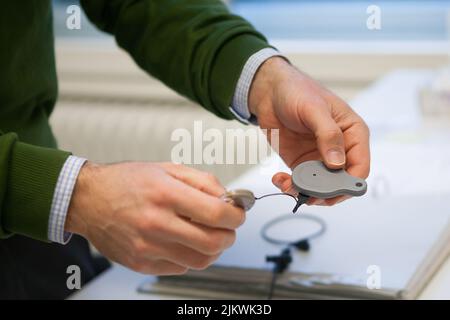 Behandlung von Geburtsohrenbetäubung mit bilateralen Cochlea-Implantaten gibt ihm ein Toningenieur einen Hörtest, um sie anzupassen. Stockfoto