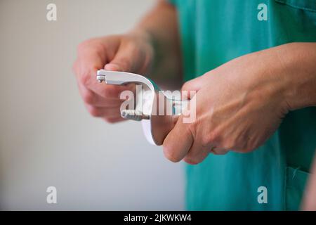 Vor der Sterilisation chirurgischer Instrumente stellt ein Pflegeassistent die im Operationssaal verwendeten Instrumentenkisten neu zusammen. Stockfoto