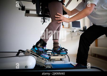 Gangtraining durch Roboterunterstützung, um Rehabilitationsübungen zu erleichtern. Stockfoto