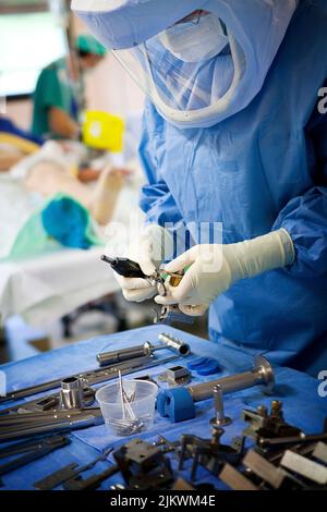 Orthopädische Chirurgie, eine Krankenschwester bereitet die chirurgischen Instrumente für die Montage einer Knieprothese. Stockfoto