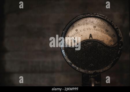 Nahaufnahme eines alten elektrischen und abgenutzten industriellen Stromzählers. Messung in Ampere. Konkreter Hintergrund, der Platz für die Kopie bietet. Stockfoto