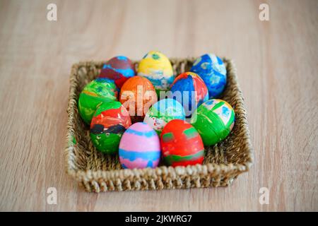 Die bunt bemalten Eier im Strohkorb zu Ostern Stockfoto