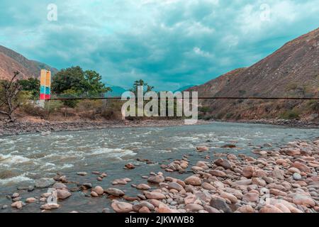 Landschaftlich reizvolle Landschaft mit einem flachen Fluss, der im Gebiet der Chicamocha-Schlucht in der Region Santander, Kolumbien, fließt Stockfoto