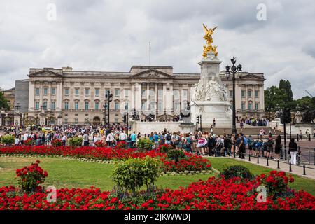Blühende Blumen rund um den Buckingham Palace in London, die im Juli 2022 zu sehen waren, als sich Touristen versammeln, um den Wechsel des Wachzemony zu beobachten. Stockfoto