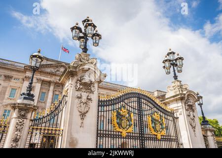 Blick auf die Haupttore vor dem Buckingham Palace in London im August 2022, als ein Union Jack im Wind kräuselt. Stockfoto