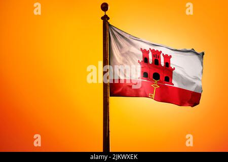 Die Nationalflagge von Gibraltar auf einem Fahnenmast isoliert auf einem orangen Hintergrund Stockfoto