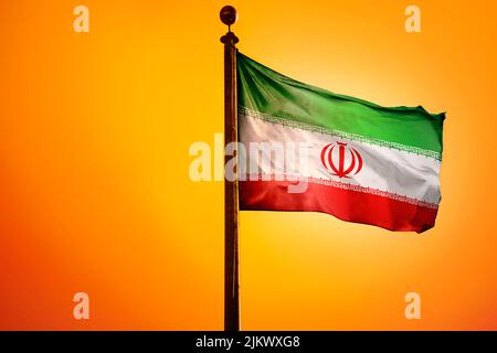 Die Nationalflagge des Iran auf einem Fahnenmast isoliert auf einem orangen Hintergrund Stockfoto