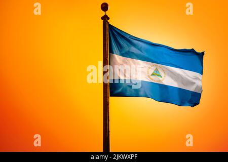 Die Nationalflagge von El Salvador auf einem Fahnenmast isoliert auf einem orangen Hintergrund Stockfoto