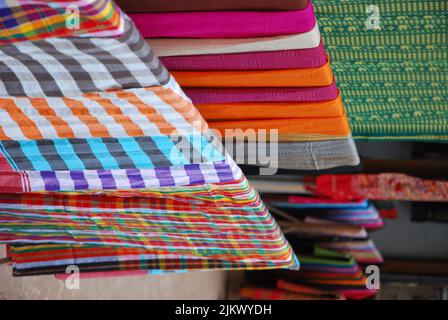 Traditionelle Loas Weberei Dorf mit Textilien zum Verkauf auf Bambus Kleiderbügel gehängt. Stockfoto