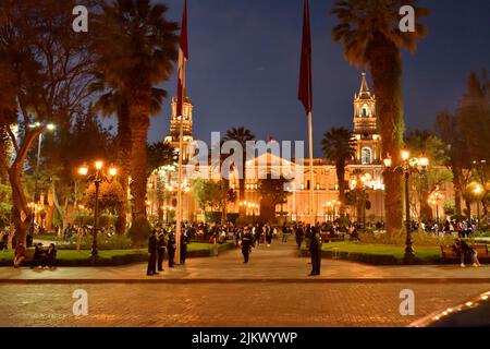 Die Menschen, die nachts auf dem Hauptplatz gegen die Kathedrale von Arequipa in Peru spazieren Stockfoto