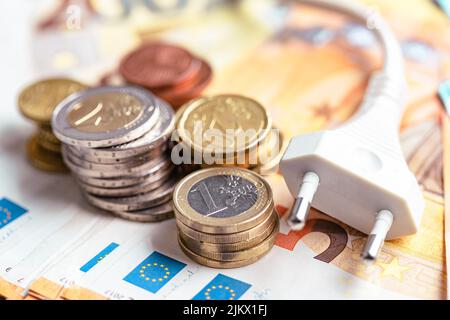 Das Energieeinsparkonzept mit Netzstecker und Euro-Geld Stockfoto