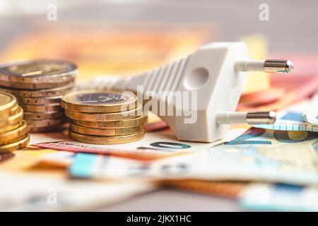 Das Energieeinsparkonzept mit Netzstecker und Euro-Geld Stockfoto