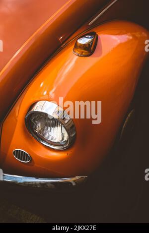 Historischer Oldtimer VW Käfer mit oranger Farbe. Der Oldtimer befindet sich in der Innenstadt von München und passt gut in die historische Landschaft Stockfoto