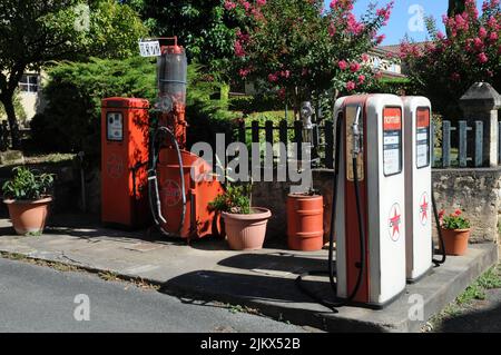 Historische Zapfsäulen für Benzin und Zweitakt im Dorf Molières im Departement Dordogne im Südwesten Frankreichs. Stockfoto