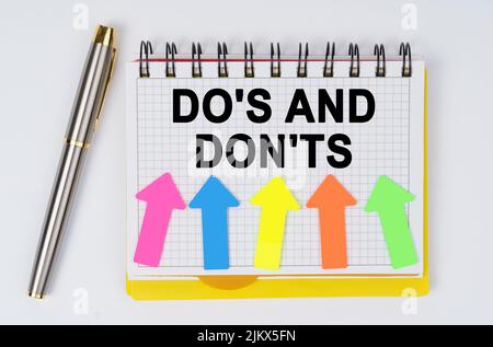 Geschäfts- und Finanzkonzept. Auf weißem Grund liegen ein Stift und ein Notizbuch mit der Aufschrift - DO S UND DON TS Stockfoto