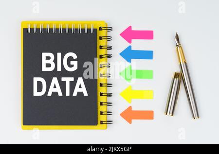 Geschäfts- und Finanzkonzept. Auf weißem Grund liegt ein Stift, Pfeile und ein Notizbuch mit der Aufschrift - BIG DATA Stockfoto