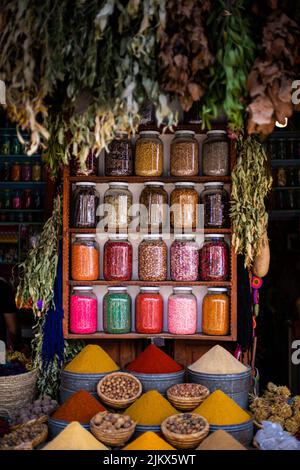 Verschiedene helle Farben Gewürze in Glas Empfänger in einer Reihe in einem Gewürzmarkt Shop in Marrakesch, Marokko Stockfoto