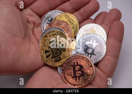 Viele Bitcoins-Münzen auf Handinnenhand. Kryptowährungskonzept, Bitcoin BTC auf Handinnenhand stehend. Kryptowährung liegt auf Mann zwei Hände Close-Up. Stockfoto