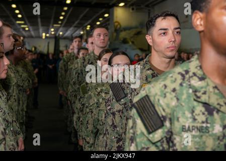 Philippinische See. 11.. Juli 2022. Matrosen stehen während einer feierlichen Zeremonie in der Hangarbucht des einzigen vorwärts eingesetzten Flugzeugträgers der US-Marine USS Ronald Reagan (CVN 76) in Formation. Während der Zeremonie wurden 192 Matrosen von Ronald Reagan zur nächsten Gehaltsstufe gebracht. Ronald Reagan, das Flaggschiff der Carrier Strike Group 5, stellt eine kampfbereite Kraft zur Verfügung, die die Vereinigten Staaten schützt und verteidigt und Allianzen, Partnerschaften und kollektive maritime Interessen in der Indo-Pazifik-Region unterstützt. Quelle: U.S. Navy/ZUMA Press Wire Service/ZUMAPRESS.com/Alamy Live News Stockfoto