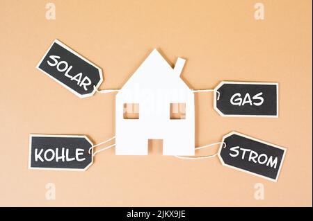 Haus, in deutscher Sprache die Wörter Solar, Kohle, Gas und Strom stehen auf Tags, erneuerbare substainable Energie gegen Umweltschädigung Stockfoto