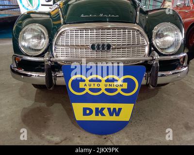 Avellaneda, Argentinien - 3. Apr 2022: Altes blaues und gelbes Auto Union Emblem und Branding auf dem Kühlergrill einer DKW 1000 S Limousine 1960s. Stockfoto