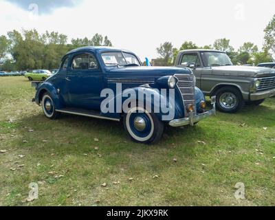 Chascomus, Argentinien - 9. Apr 2022: Altes blaues Chevrolet Chevy Master Business Coupé 1938 von GM. Grüne Natur Gras und Bäume Hintergrund. Oldtimer-sh Stockfoto