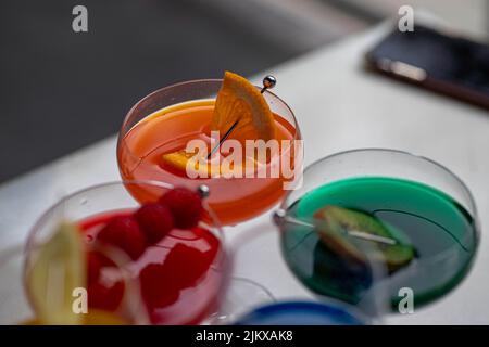 Bunte Cocktails in Gläsern mit Obst und Beeren Stockfoto